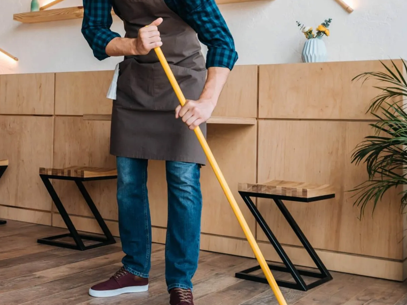 Worker sweeping wood floor in a cafe | Floor Systems in Lisbon, ME