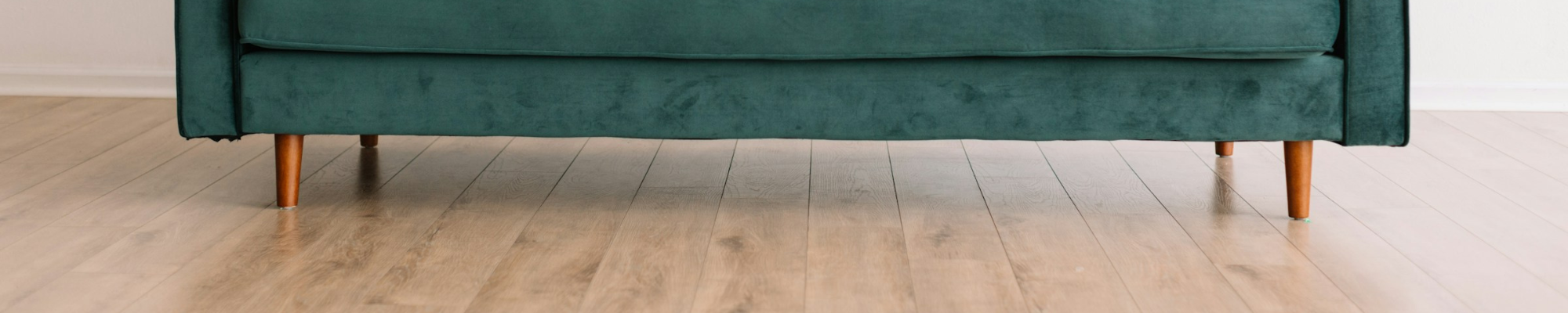 Laminate floor with a green velvet sofa at Floor Systems in Lisbon, ME