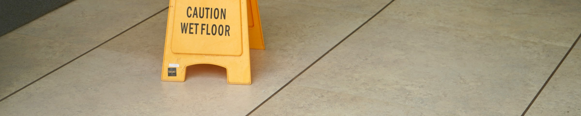 Clean Commercial Tile Floor with Caution Sign | Floor Systems in Lisbon, ME